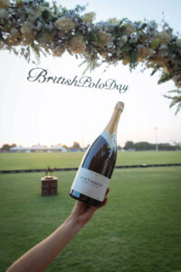 wine bottle held in front of floral arch