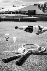 pouring wine into glasses on a tennis court