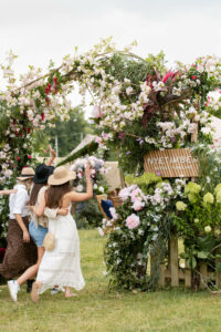 women going under floral arch