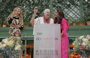 women event speaking, holding wine glasses