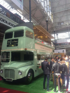 green bus with people standing beside, conversing
