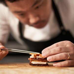 a chef piecing together a gourmet dish