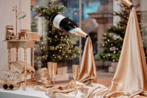 suspended wine bottles with gold silk flowing from the opening