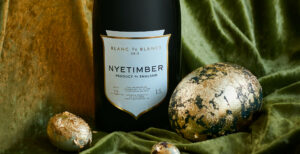 a bottle of Nyetimber blanc de blancs wine next to a large and small easter egg