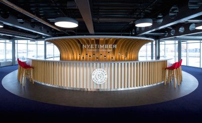 circular bar with red chairs around showcasing bottles of wine